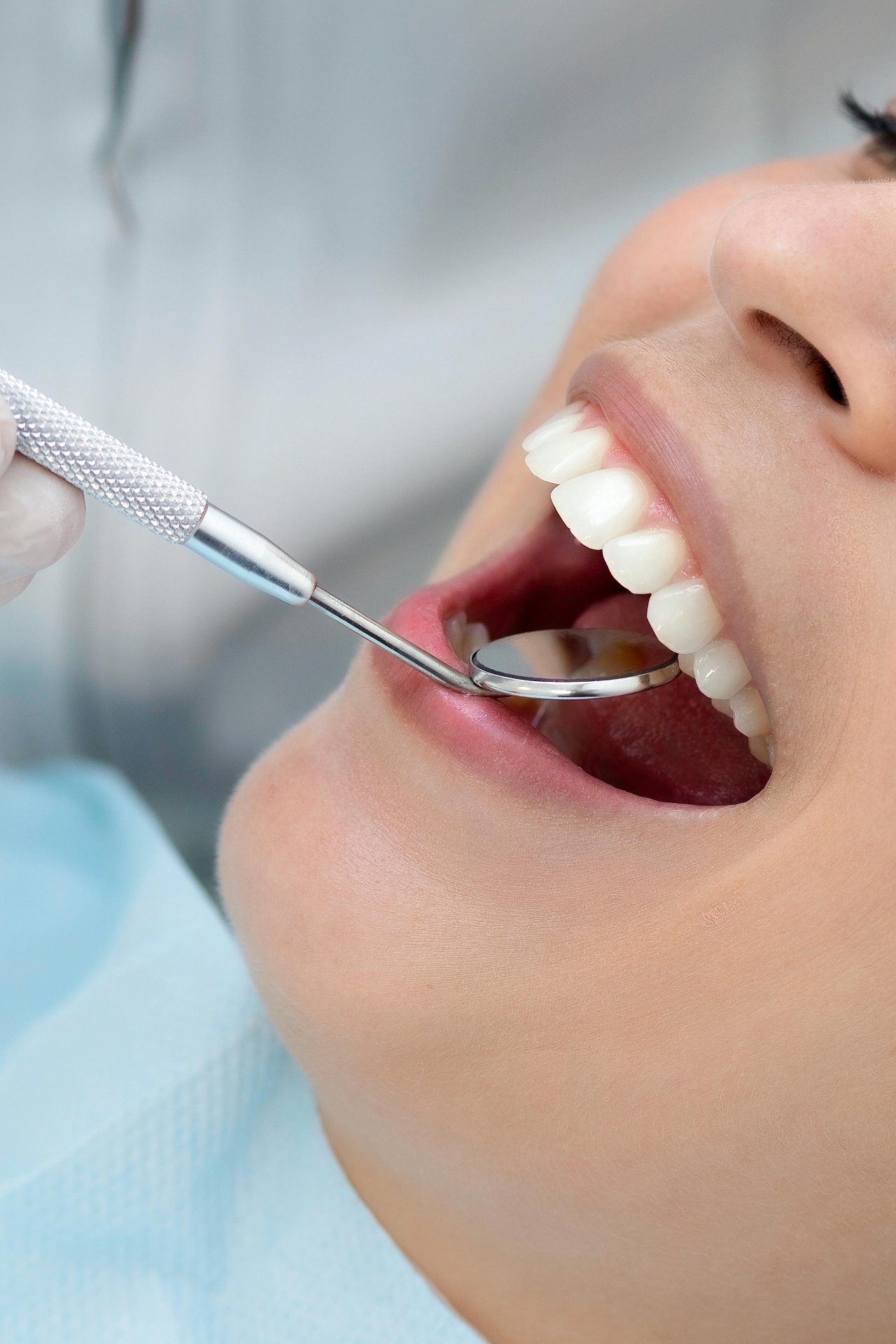 Close-up of healthy teeth being examined with a dental mirror