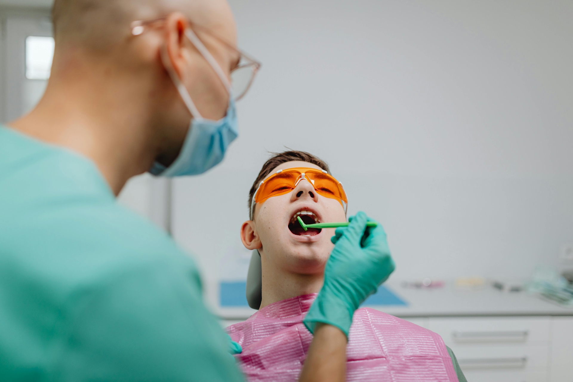 Dentist applying professional whitening gel with protective eyewear